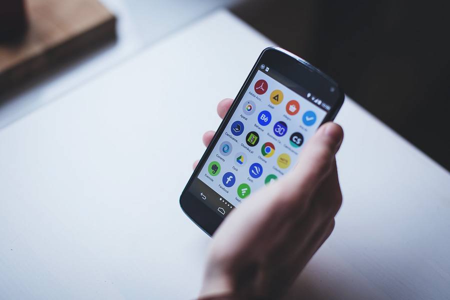 Pengguna memegang ponsel untuk verifikasi keamanan akun